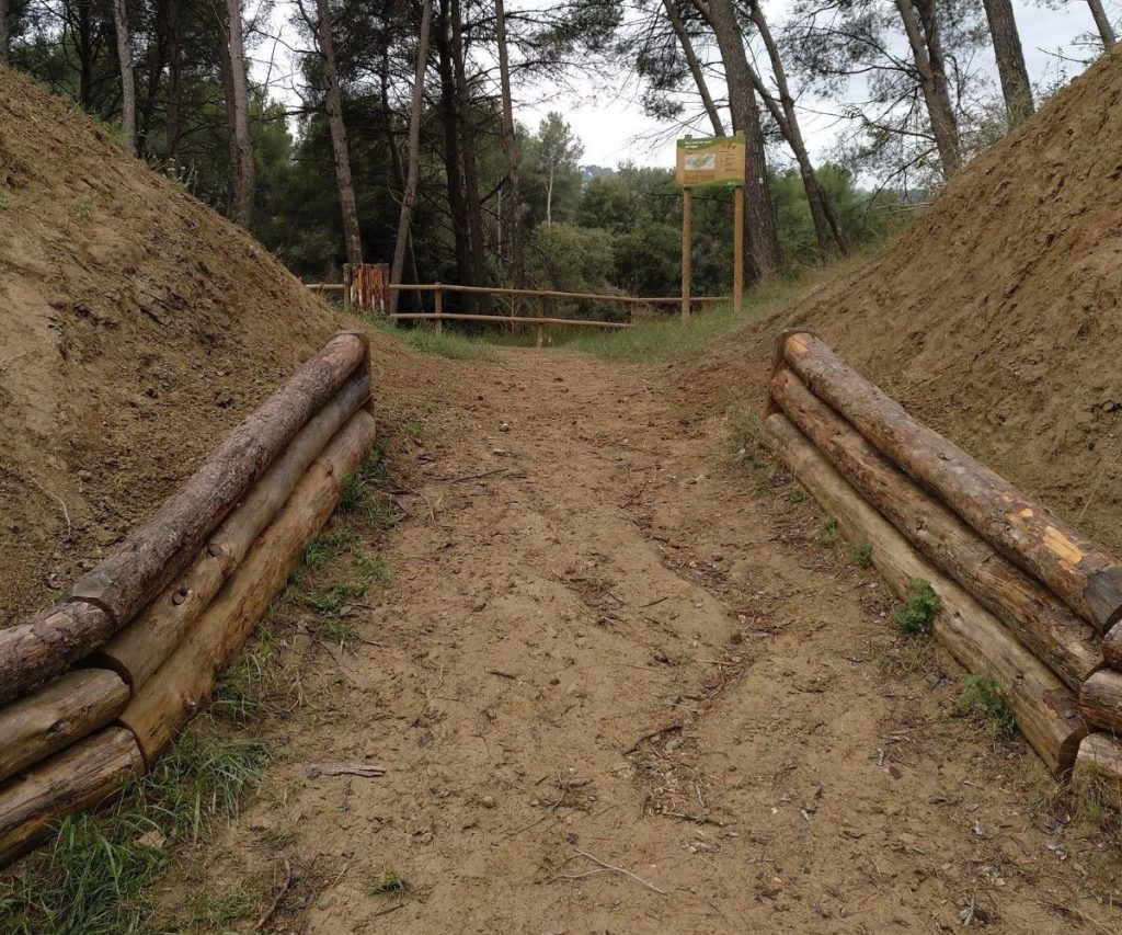 Entrada a una pista forestal construida con troncos